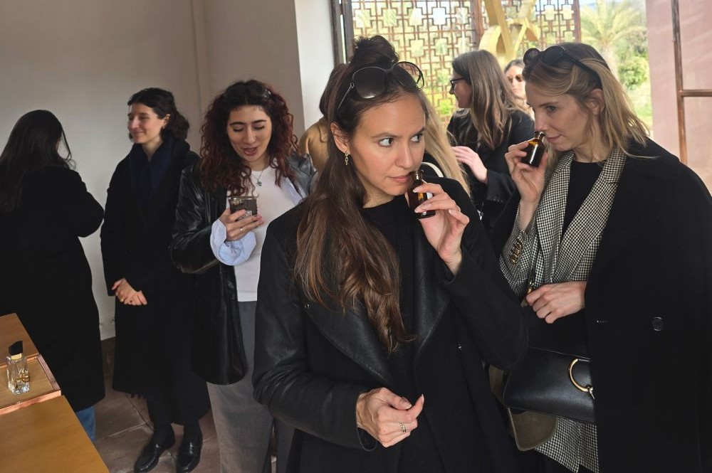 group of women in a room smelling perfume samples 