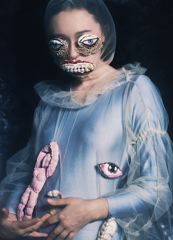feminine model wearing blue dress with white mesh overlay with jeweled mouth and eye details